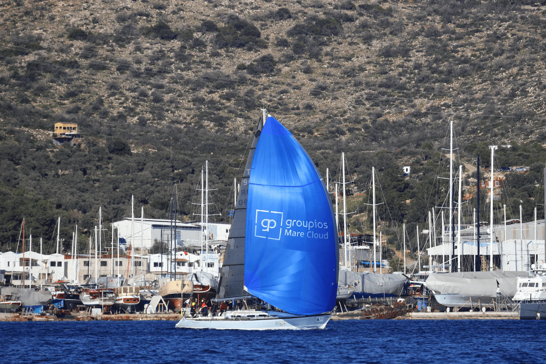 Sailboat with groupios Mare Cloud spinnaker in a marina
